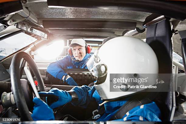 crew member and stock car driver communicating - pit stock-fotos und bilder