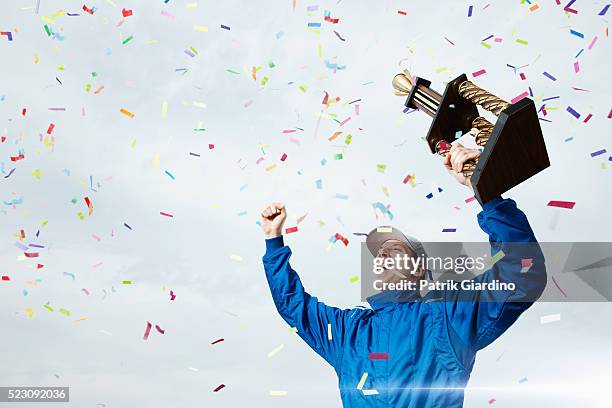 race car driver holding trophy - holding trophy cup stock pictures, royalty-free photos & images