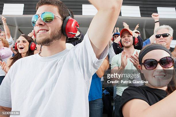 spectators watching car racing - watching nascar stock pictures, royalty-free photos & images