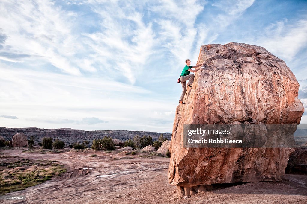 Rock climber climbing up sandstone boulder, Grand Junction, Mesa County, Colorado, USA