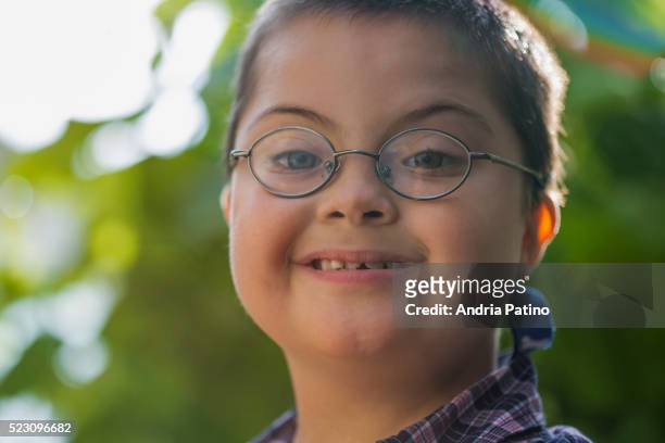 smiling young boy making eye contact - grübchen stock-fotos und bilder