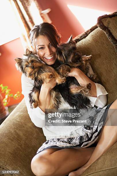 woman on sofa holding her two dogs - yorkshire terrier imagens e fotografias de stock