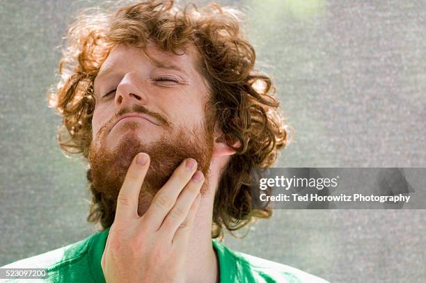 young man with hand on beard - beard stock pictures, royalty-free photos & images