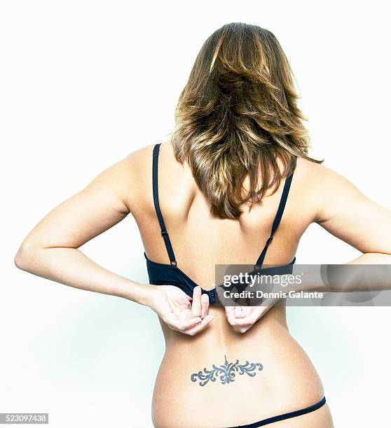 young woman fastening bra - back tattoo stock pictures, royalty-free photos & images