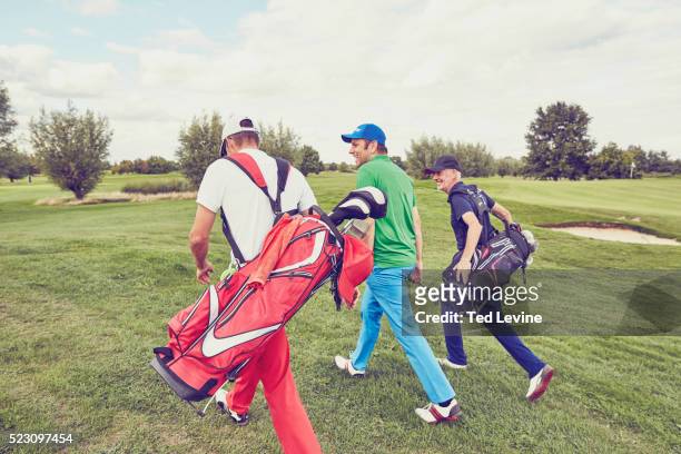 mid-adult men talking on golf course - golf bag stock pictures, royalty-free photos & images