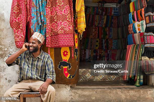 small business owner on phone in east african market - african market stock pictures, royalty-free photos & images