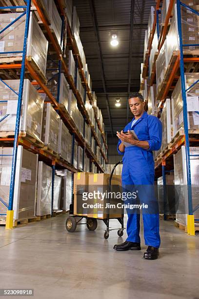 man working in warehouse - macacão preto imagens e fotografias de stock
