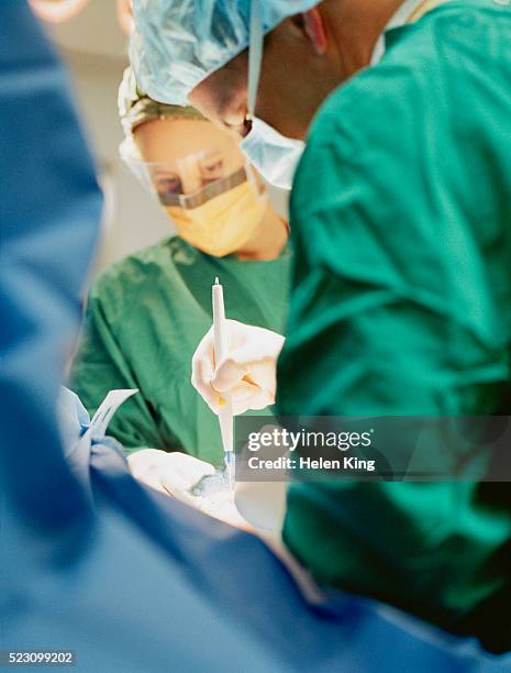 cosmetic surgeon using cauterizing cutter - cauterizing stock pictures, royalty-free photos & images