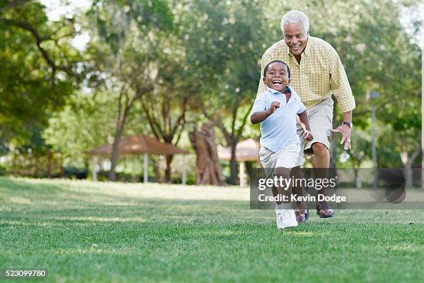 grandfather playing with grandson in park - grandad and grandkid stockfoto's en -beelden