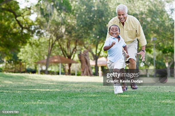 grandfather playing with grandson in park - grandfather stock pictures, royalty-free photos & images