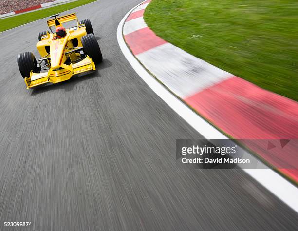 open-wheel single-seater racing car racecar speeding through corner - rinnsteinkante stock-fotos und bilder