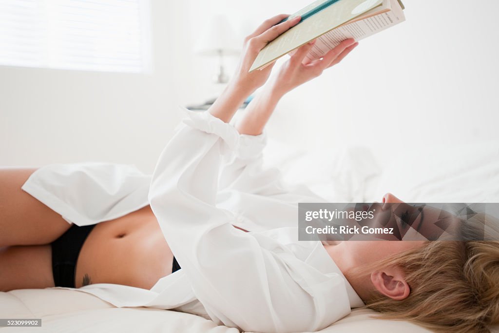 Blond woman reading in bed