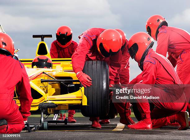 pit crew changing tire on racecar - pit stop stock pictures, royalty-free photos & images