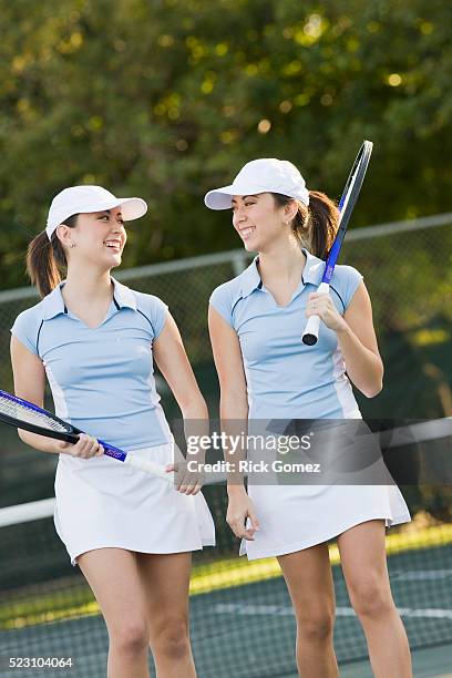 twin sisters playing tennis - asian twins stockfoto's en -beelden