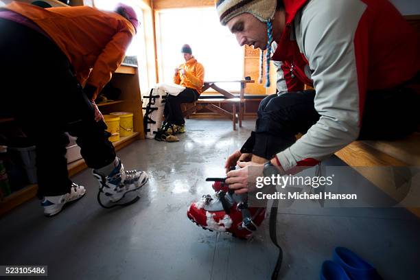 people adjusting ski boot - skischoen stockfoto's en -beelden