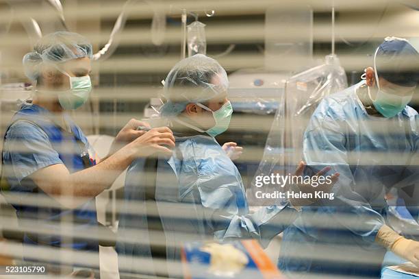 surgeons preparing for surgery - operating gown stock pictures, royalty-free photos & images