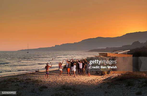 party in front of beach hut at sunset - fête de plage photos et images de collection