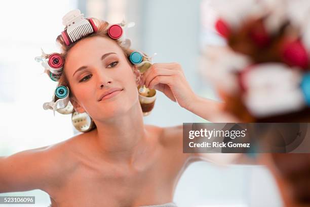 teenage girl in curlers trying on earrings - papiljott bildbanksfoton och bilder