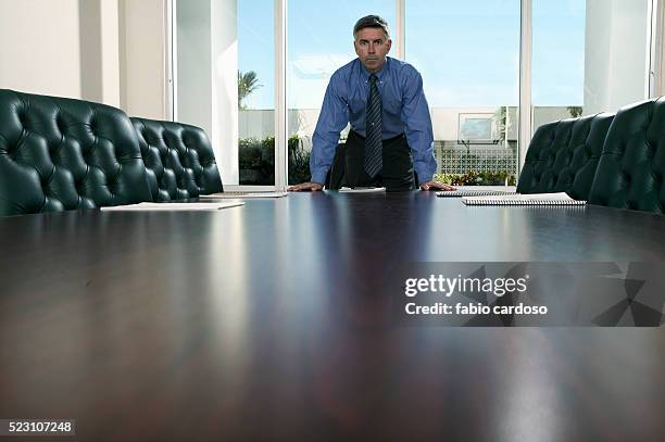 businessman leaning over conference table - disappoint bussiness meeting stock pictures, royalty-free photos & images