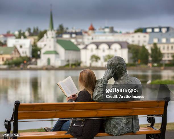 woman reading next to statue of an icelandic poet, tomas gudmundsson, reykjavik, iceland - 詩 個照片及圖片檔