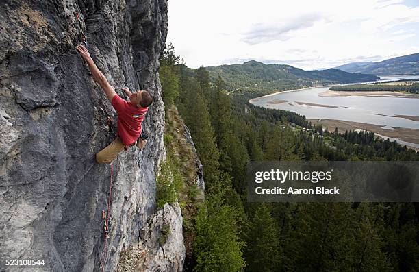 rock climber on a cliff face - freiklettern stock-fotos und bilder