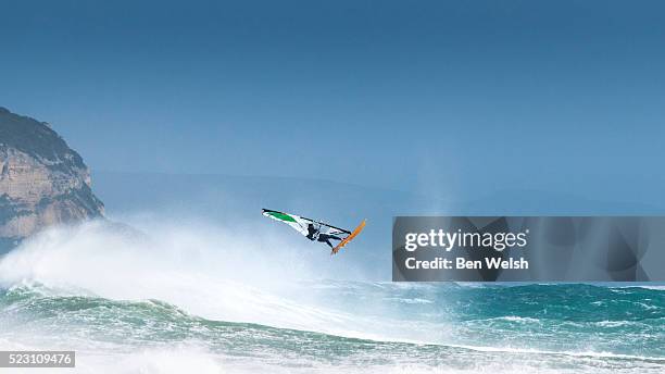 windsurfer jumping a wave. - windsurfbrett stock-fotos und bilder