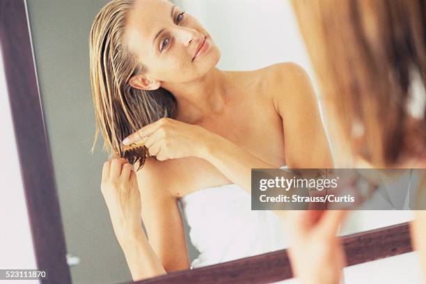 woman combing hair in mirror - beautiful hair at home stock-fotos und bilder