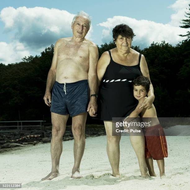 older couple with their grandson at the beach. - fat man on beach stock pictures, royalty-free photos & images