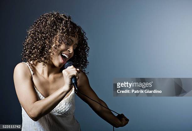 young woman singing - zangeres stockfoto's en -beelden