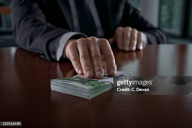 businessman putting euro bills on table - 貪污 個照片及圖片檔