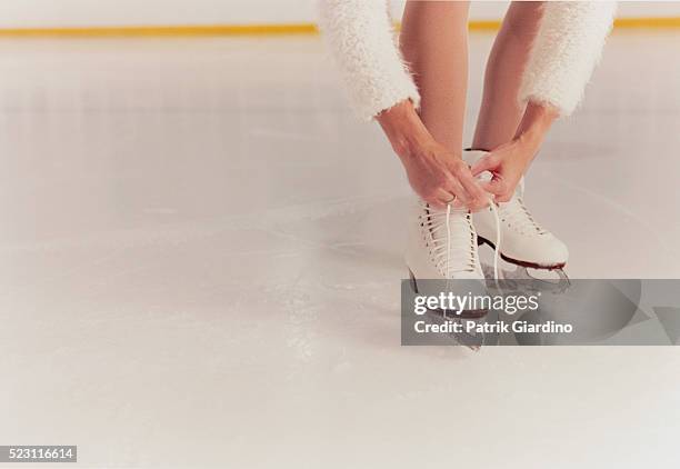 figure skater tying laces - patinaje artístico fotografías e imágenes de stock