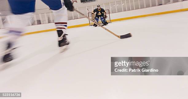 hockey player skating toward goal - hockey keeper stockfoto's en -beelden
