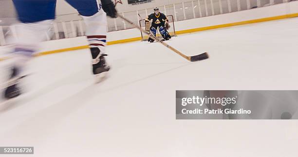 hockey player skating toward goal - hockey goalkeeper stock pictures, royalty-free photos & images