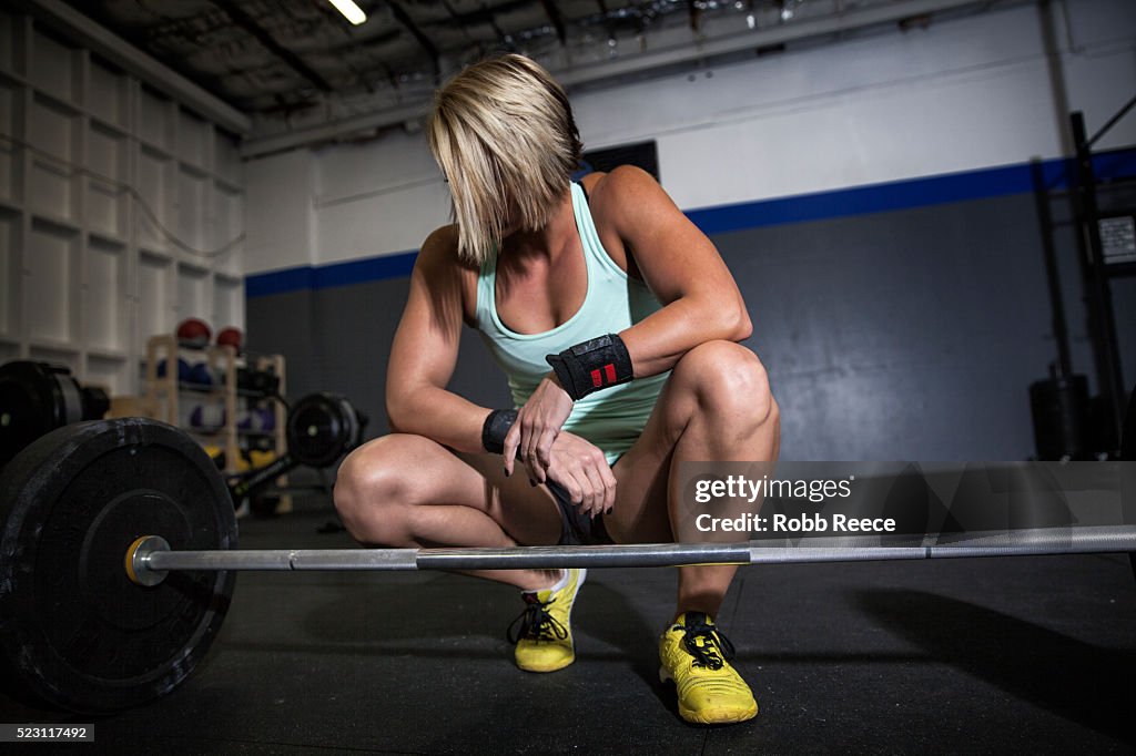 Woman preparing to lift weights in gym gym