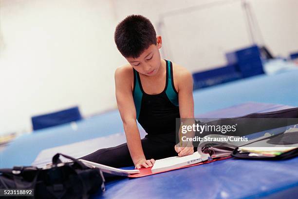 young gymnast doing school work - bar mat stock pictures, royalty-free photos & images