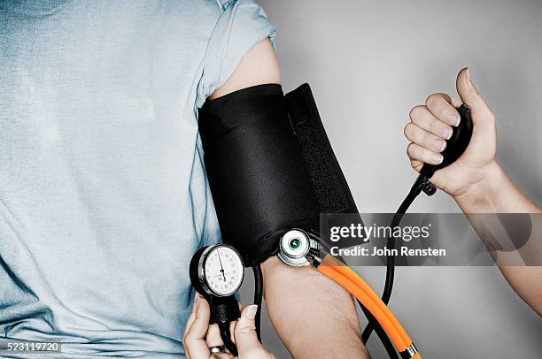 man having his blood pressure checked - blood pressure stock-fotos und bilder