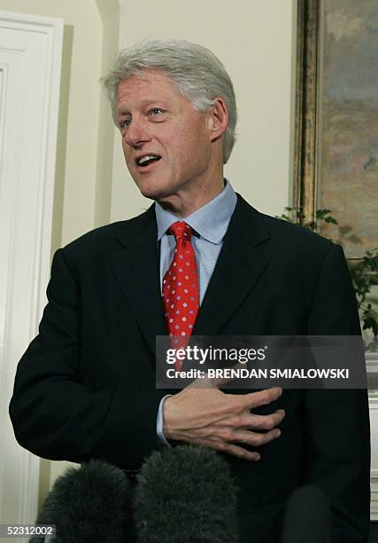 Former US President Bill Clinton gestures to his heart while discussing his health in the Roosevelt Room of the White House 08 March, 2005 in...