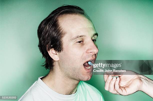 swabbing a man's mouth - cotton bud stock pictures, royalty-free photos & images