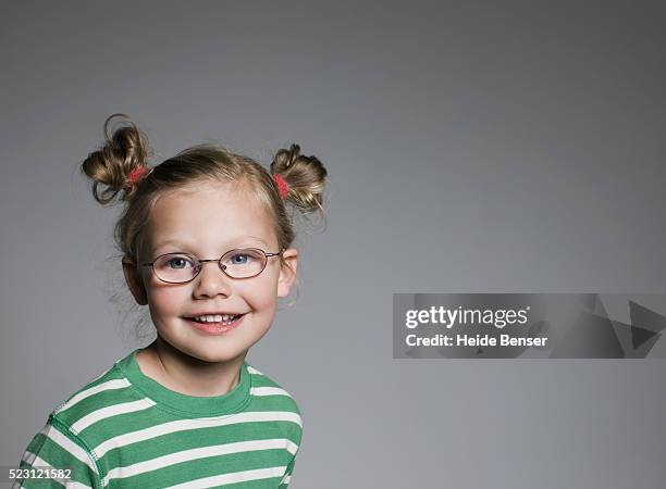 smiling girl wearing eyeglasses - child portrait studio stock-fotos und bilder