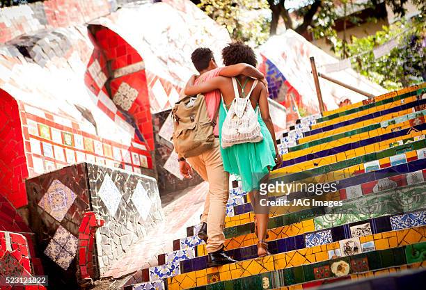 couple walking up steps on escadaria selaron, rio de janeiro, brazil - escadaria fotografías e imágenes de stock