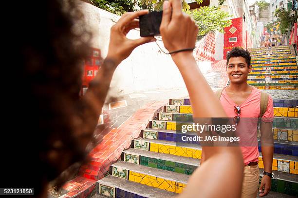 woman taking photo of her boyfriend on escadaria selaron, rio de janeiro, brazil - escadaria fotografías e imágenes de stock