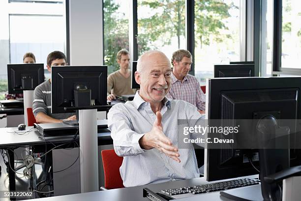 middle aged businessman in a computer class excited about his success - computer training stock pictures, royalty-free photos & images