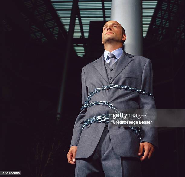 businessman chained to a pole - tangled stock-fotos und bilder