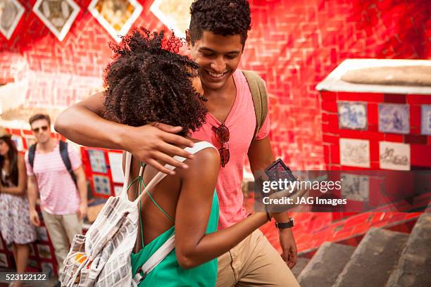 couple looking at camera on escadaria selaron, rio de janeiro, brazil - escadaria fotografías e imágenes de stock