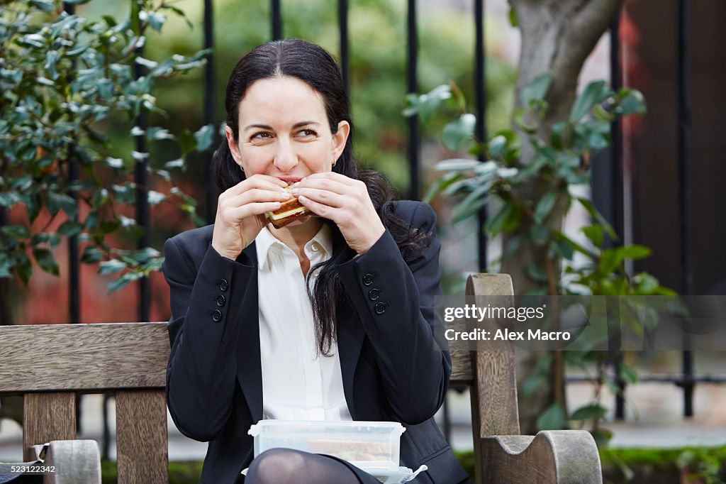 Businesswoman eating lunch and texting