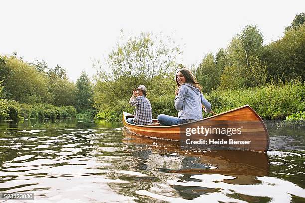 couple canoeing on a river - piragüismo fotografías e imágenes de stock