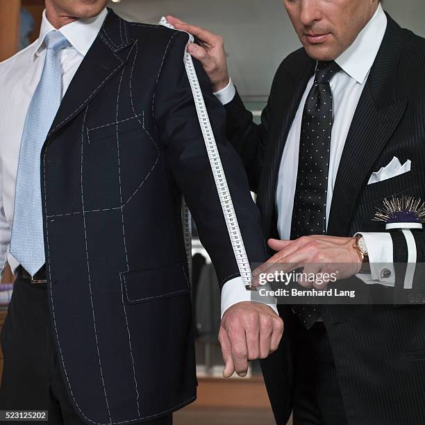 tailor getting customer's measurements - schneider stock-fotos und bilder