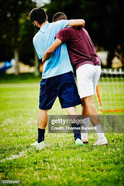 soccer teammates embracing after winning game - fairness stock-fotos und bilder
