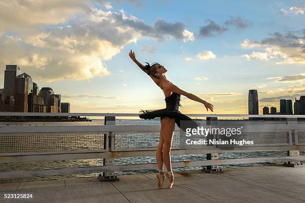 ballerina wearing black tutu and dancing outside at sunset, new york city, new york state, usa - urban ballet stockfoto's en -beelden