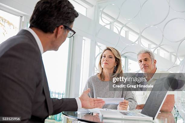 couple talking to financial advisor - lebensversicherung stock-fotos und bilder